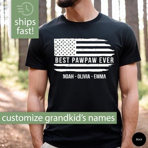 May include: Black t-shirt with a distressed American flag design and the text "Best Pawpaw Ever" with the names "Noah - Olivia - Emma" underneath.