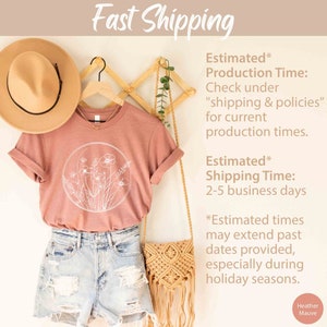 May include: A heather mauve t-shirt with a white floral design in a circle. The t-shirt is hanging on a wooden hanger with a straw hat and a woven bag. The text "Fast Shipping" is at the top of the image. The text "Estimated* Production Time: Check under "shipping & policies" for current production times." is in the upper right corner. The text "Estimated* Shipping Time: 2-5 business days" is in the middle right corner. The text "*Estimated times may extend past dates provided, especially during holiday seasons." is in the lower right corner. The text "Heather Mauve" is in the lower right corner.