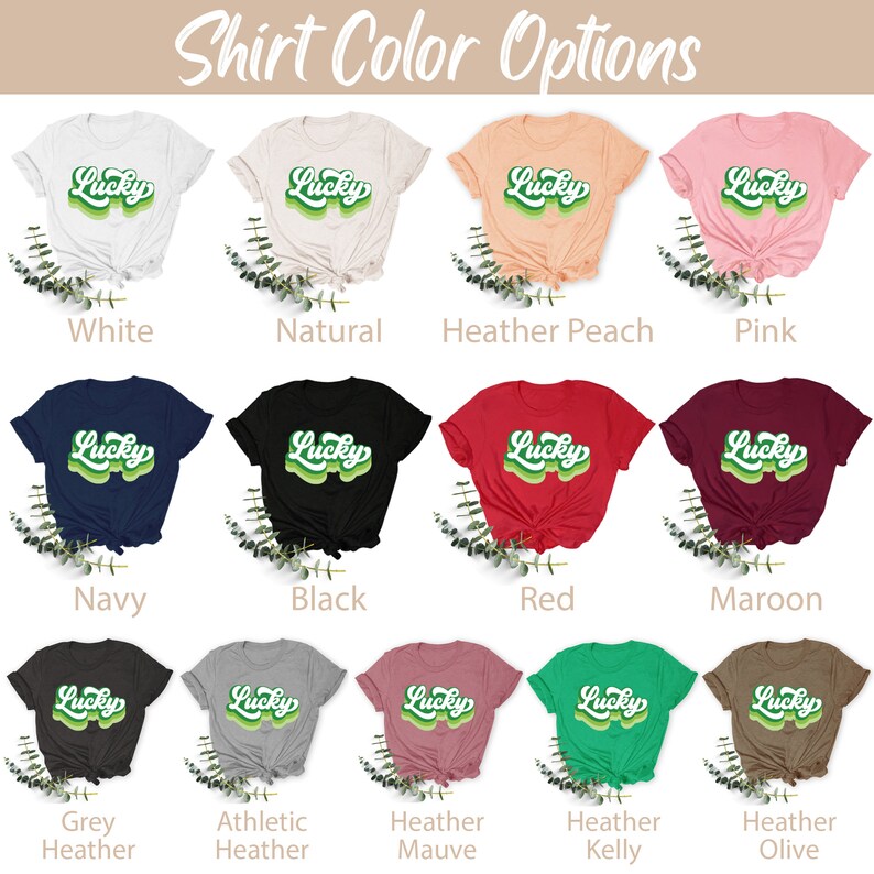 May include: A chart showing different t-shirt colors with the word "Lucky" in a retro green font on each shirt. The colors include white, natural, heather peach, pink, navy, black, red, maroon, grey heather, athletic heather, heather mauve, heather kelly, and heather olive.