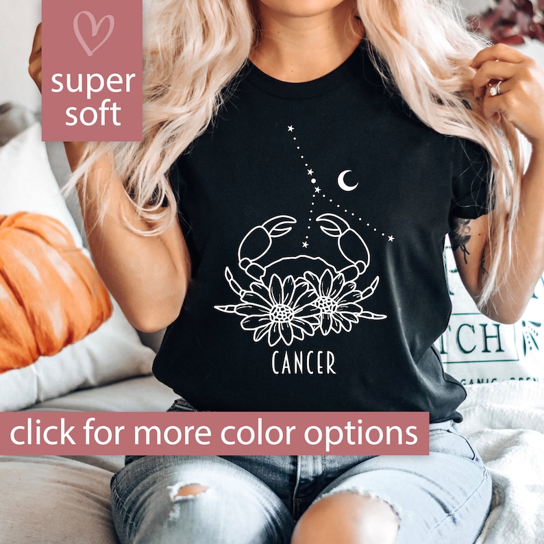 May include: Black t-shirt with a white outline of a crab, flowers, and the word "Cancer".