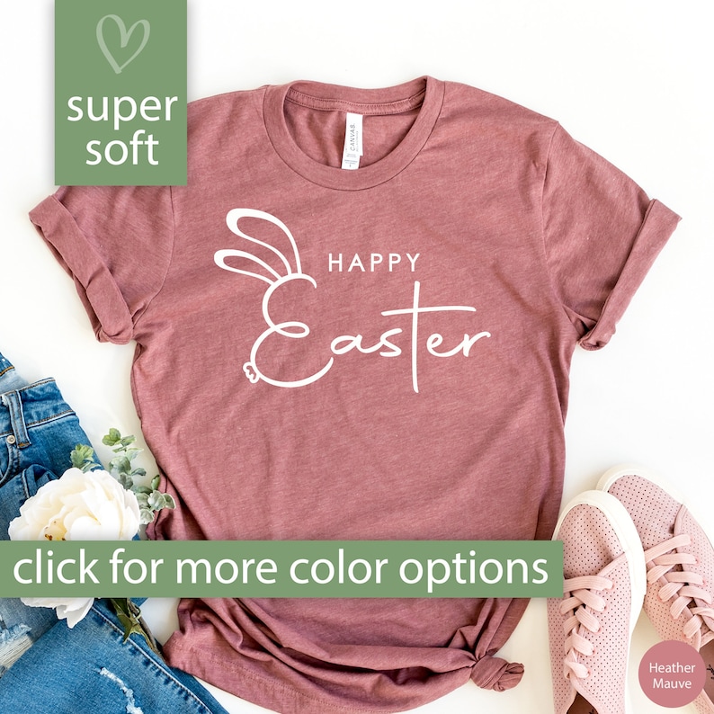 May include: A heather mauve t-shirt with a white outline of a bunny rabbit and the text "Happy Easter".