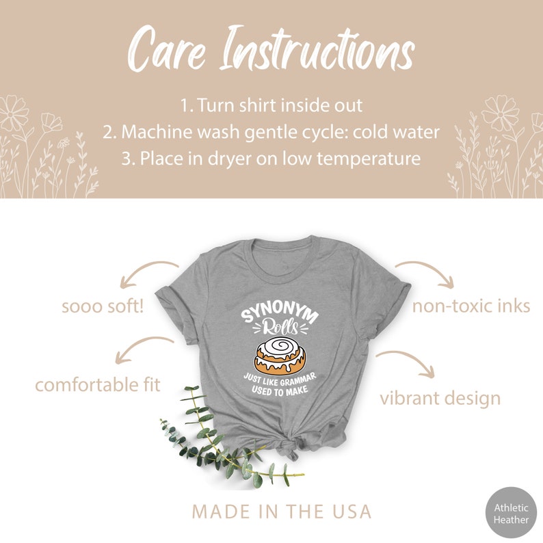 May include: A gray t-shirt with a cinnamon roll graphic and the text "SYNONYM = Rolls" and "JUST LIKE GRAMMAR USED TO MAKE". The shirt is made in the USA and features a comfortable fit, non-toxic inks, and a vibrant design.