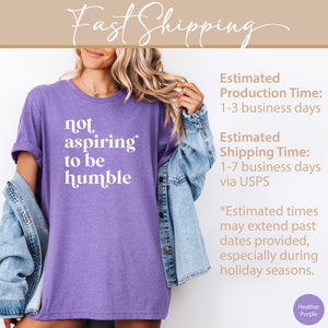 May include: Purple heather t-shirt with the text "not aspiring to be humble" printed in white.