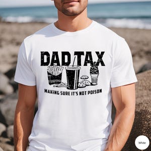 K&ouml;nnte beinhalten: Wei&szlig;es T-Shirt mit schwarzem Text, der "Dad Tax Making Sure It's Not Poison" lautet. Der Text ist von Bildern von Pommes, einem Getr&auml;nk, Keksen und einem Eis umgeben.