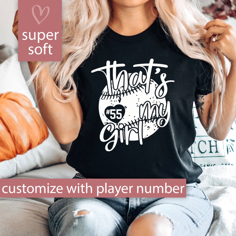 May include: Black t-shirt with a white baseball graphic and the text "That's my girl" with a heart and the number 55. Customize with player number.