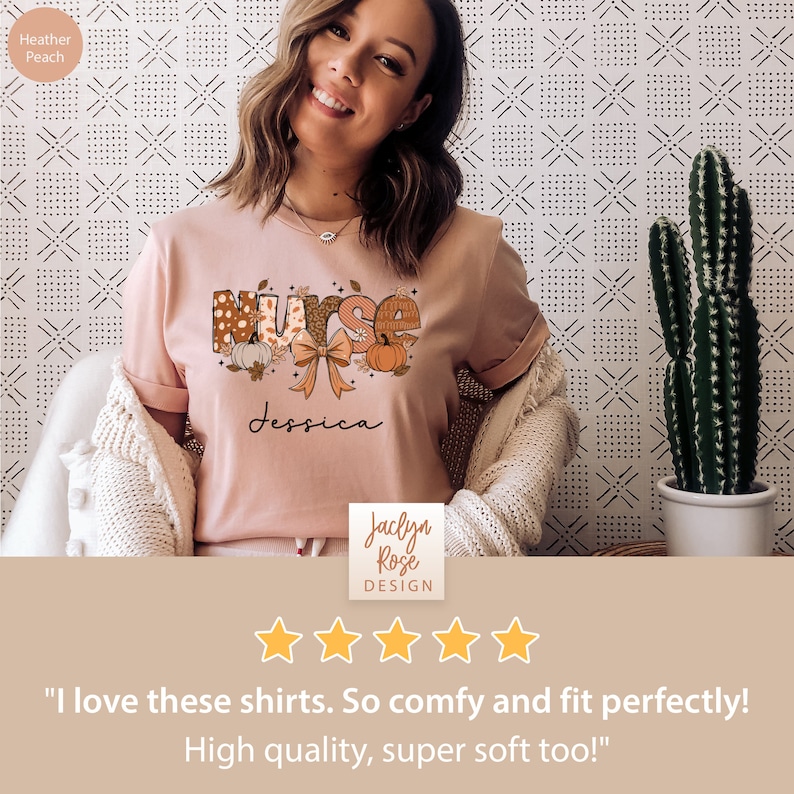 May include: A pink t-shirt with a fall-themed "Nurse" graphic featuring pumpkins, leaves, and a bow. The text "Jessica" is printed below the graphic. The shirt is on a model and has a five-star rating with the text "I love these shirts. So comfy and fit perfectly! High quality, super soft too!"