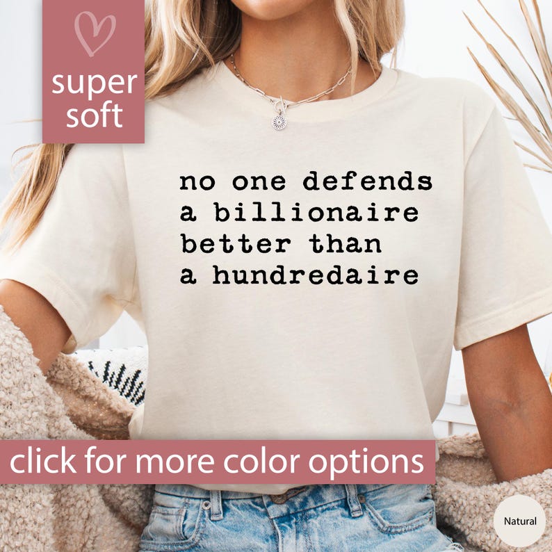 K&ouml;nnte beinhalten: Ein wei&szlig;es T-Shirt mit dem Text "no one defends a billionaire better than a hundredaire" in Schwarz gedruckt. Das Shirt ist super weich und hat eine lockere Passform.