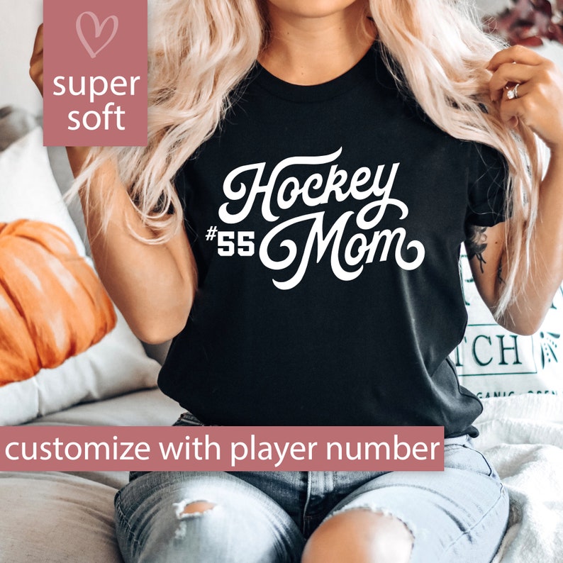 Peut inclure: T-shirt noir avec un texte blanc qui dit "Hockey #55 Mom" dans une police d'&eacute;criture cursive. Le t-shirt est personnalisable avec un num&eacute;ro de joueur.