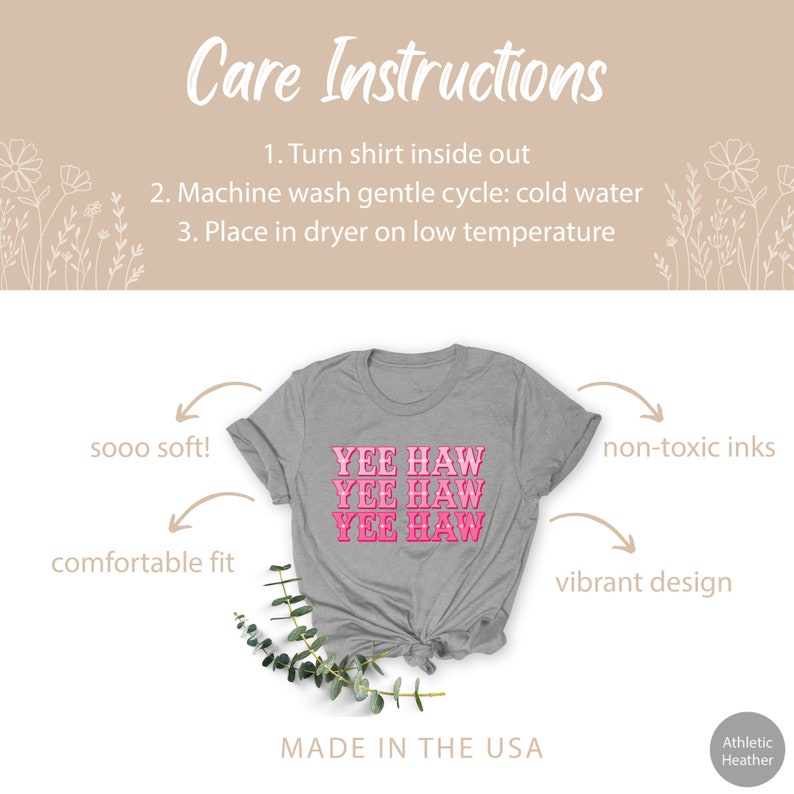 May include: Gray t-shirt with the phrase "Yee Haw" repeated three times in pink lettering. The shirt is made in the USA and features a comfortable fit, soft fabric, and non-toxic inks.