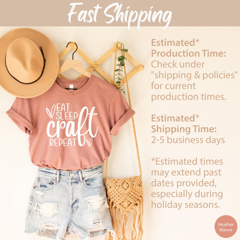 May include: A pink t-shirt with the text "Eat Sleep Craft Repeat" in white lettering. The shirt is hanging on a wooden hanger with a straw hat and a woven bag. The text "Estimated Production Time: Check under "shipping & policies" for current production times. Estimated Shipping Time: 2-5 business days *Estimated times may extend past dates provided, especially during holiday seasons. Heather Mauve" is written in black text on a white background.