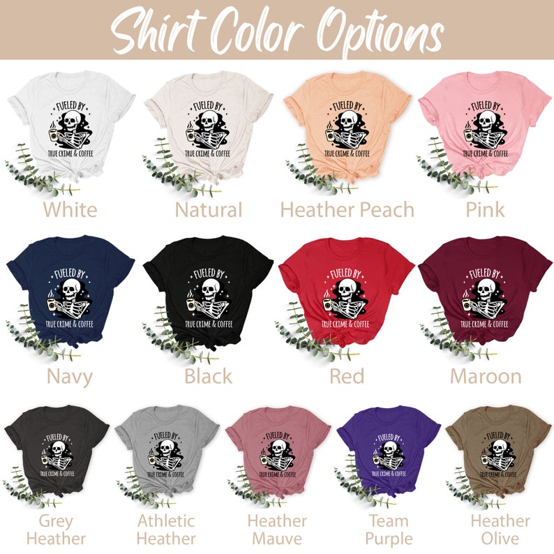 May include: A graphic t-shirt design featuring a skeleton holding a coffee cup with the text "Fueled by True Crime & Coffee". The shirt is available in 12 different colors: white, natural, heather peach, pink, navy, black, red, maroon, grey heather, athletic heather, heather mauve, team purple, and heather olive.