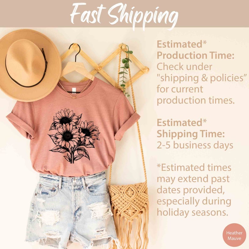 May include: A dusty rose t-shirt with a black sunflower graphic. The shirt is displayed with denim shorts, a straw hat, and a macrame bag. The words "Fast Shipping" are at the top.