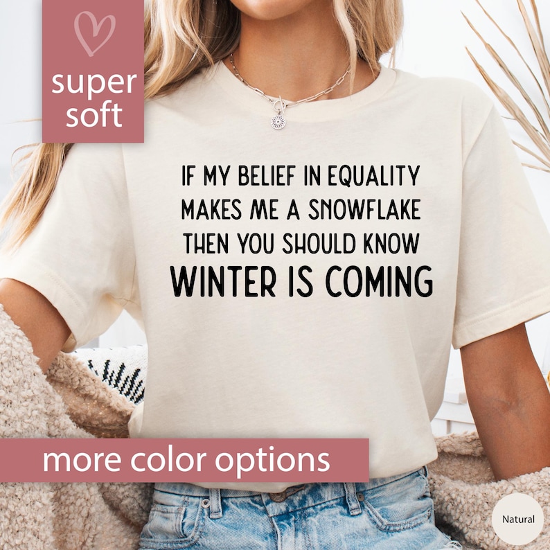 May include: White t-shirt with the text "If my belief in equality makes me a snowflake then you should know winter is coming".