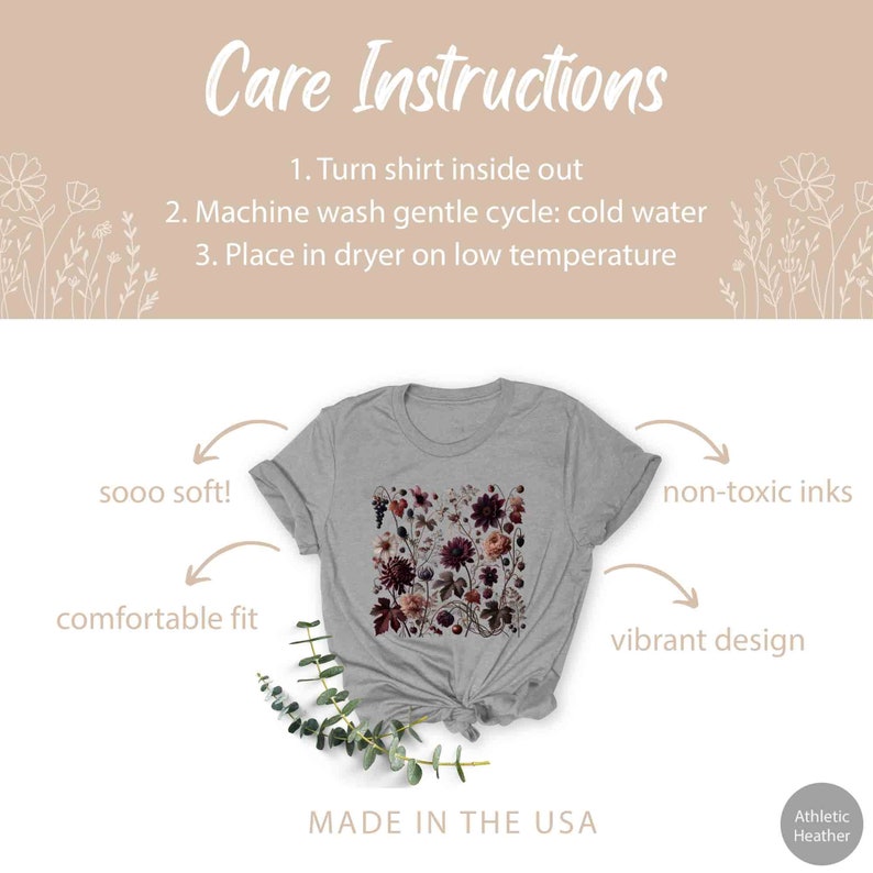 Op de afbeelding: Een heidegrijs T-shirt met een bloemenprint. Het shirt is gemaakt van zacht, comfortabel materiaal en is bedrukt met niet-giftige inkt. De tekst "sooo soft!" en "comfortable fit" staat aan de linkerkant van de afbeelding. De tekst "non-toxic inks" en "vibrant design" staat aan de rechterkant van de afbeelding. De tekst "MADE IN THE USA" staat onderaan de afbeelding. De tekst "Athletic Heather" staat in de rechterbenedenhoek van de afbeelding.