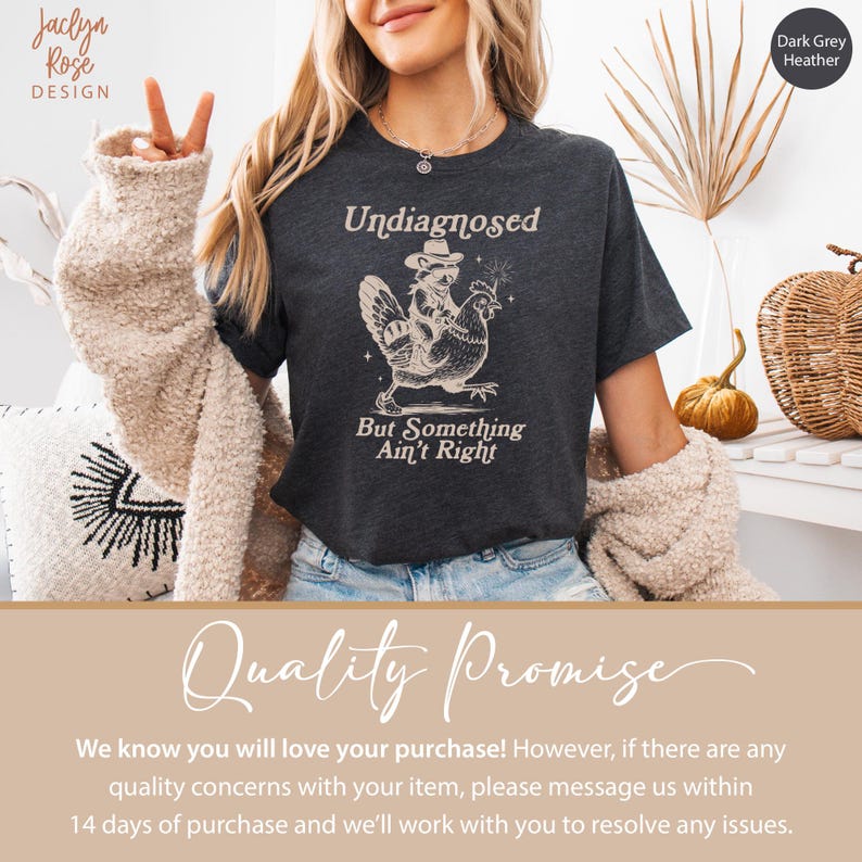 May include: Dark grey heather t-shirt with the text "Undiagnosed But Something Ain't Right" and a graphic of a cowboy riding a chicken. The shirt is a crew neck and has short sleeves.