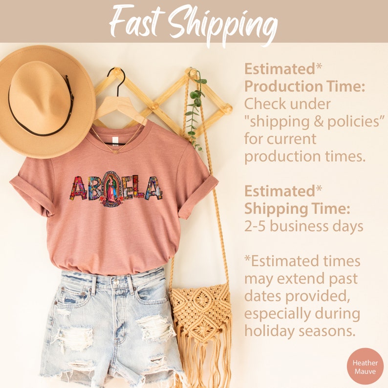 May include: A heather mauve t-shirt with the word "ABUELA" in colorful mosaic letters. The shirt is hanging on a wooden rack with a straw hat and a woven bag. The text "Estimated* Production Time: Check under "shipping & policies" for current production times. Estimated* Shipping Time: 2-5 business days *Estimated times may extend past dates provided, especially during holiday seasons. Heather Mauve" is visible on the right side of the image.