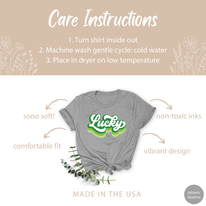 May include: A gray t-shirt with a green and white "Lucky" graphic. The shirt is made with soft, comfortable fabric and features non-toxic inks. The design is vibrant and the shirt is made in the USA.