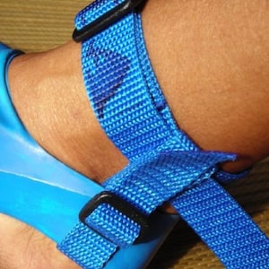 May include: Blue adjustable ankle strap with a black buckle. The strap is made of woven nylon.