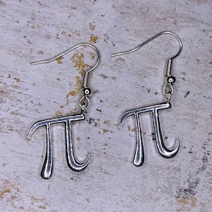 May include: A pair of silver earrings shaped like the mathematical symbol pi.