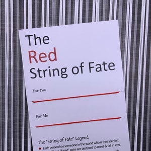 May include: Red string tied to a white card with the text "The Red String of Fate" and a description of the legend of the red string of fate.