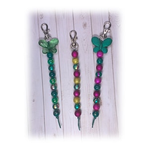 Joyas decorativas: Hermosa etiqueta para bolso, adorno para cartera o abalorio para agenda en tonos magenta y verde con cierre de mosquetón. Envío gratuito.
