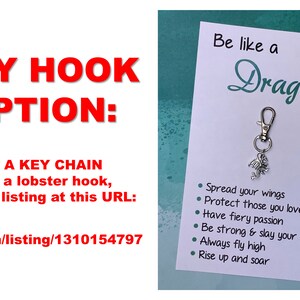 May include: A silver dragon keychain with a lobster clasp and a card that reads "Be like a Dragon" with a list of dragon-like qualities: "Spread your wings", "Protect those you love", "Have fiery passion", "Be strong & slay your fears", "Always fly high", "Rise up and soar".