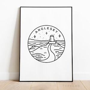 May include: Black and white line art print of a lighthouse on a hill with a road leading to it. The print is in a circle with the text "Anglesey" above it.