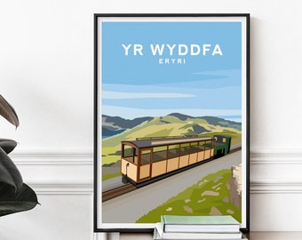 May include: A framed travel poster featuring a tan and brown mountain train on tracks against a backdrop of green hills and a blue sky. The text YR WYDDFA and ERYRI is printed in white at the top. The illustration uses flat colors and clean lines.