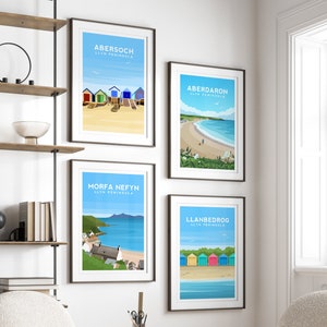 Puede incluir: Cuatro impresiones enmarcadas de diferentes escenas costeras de Gales. Cada impresi&oacute;n presenta una ilustraci&oacute;n colorida de una playa con el nombre del lugar y "Llyn Peninsula" escrito debajo. Las impresiones est&aacute;n dispuestas en una cuadr&iacute;cula en una pared blanca.