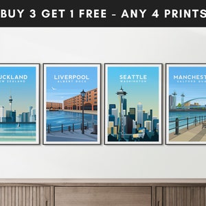 Puede incluir: Cuatro impresiones de paisajes urbanos con un esquema de color azul y blanco. Las impresiones representan Auckland, Nueva Zelanda; Liverpool, Inglaterra; Seattle, Washington; y Manchester, Inglaterra. Las impresiones est&aacute;n enmarcadas en negro y tienen un fondo blanco. El texto "BUY 3 GET 1 FREE - ANY 4 PRINTS" est&aacute; en la parte superior de la imagen.