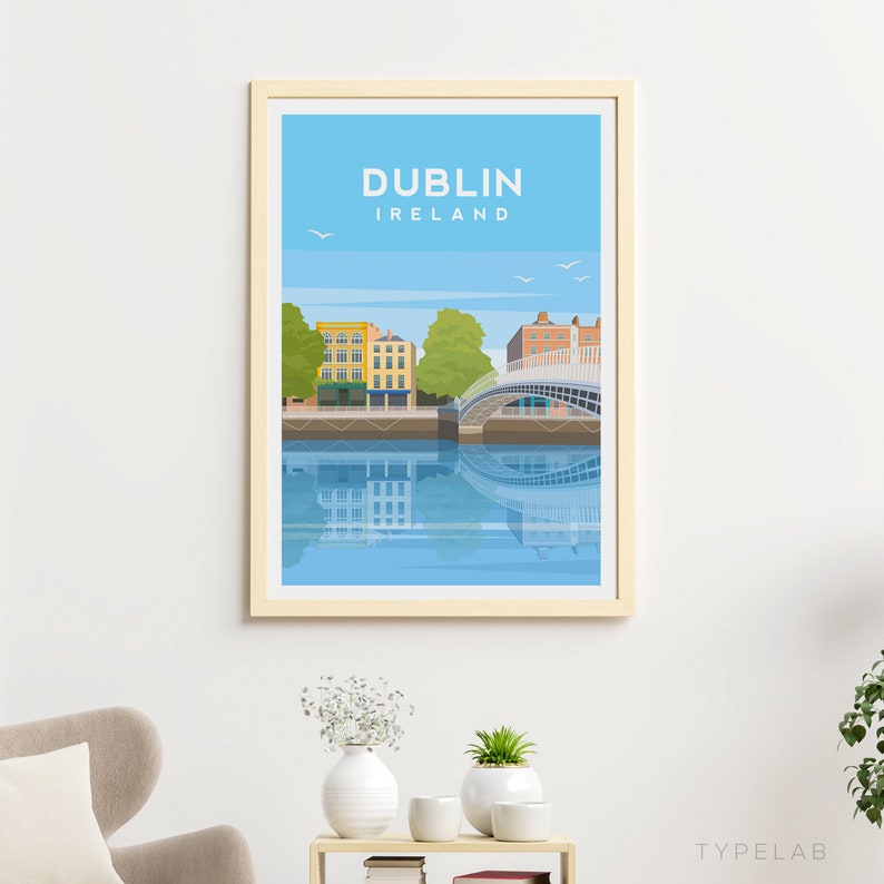 Puede incluir: Una ilustraci&oacute;n colorida del Puente Ha'penny en Dubl&iacute;n, Irlanda. El puente es blanco con un cielo azul y un reflejo de agua. El texto "DUBL&Iacute;N IRLANDA" est&aacute; en la parte superior de la imagen.