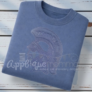 Könnte beinhalten: Ein blaues Sweatshirt mit einem gestickten Design eines spartanischen Helms. Das Wort "Applique" ist in einer Schreibschrift auf der linken Seite des Sweatshirts aufgedruckt. Darunter steht "applique and embroidery designs".