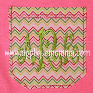 May include: A pink t-shirt with a green chevron patterned pocket. The pocket has a green embroidered monogram "ARK" on it. The text "www.appliquemomma.com" is visible below the monogram.
