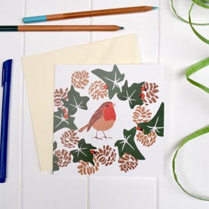 Cartão de felicitações de tordo de inverno. Com pinhas e hera.