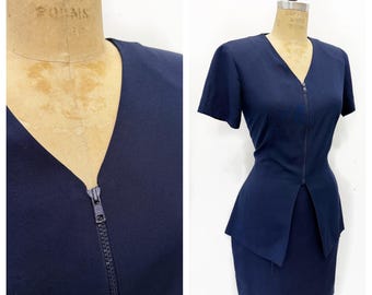 Navy 1990’s minimalist suit with short skirt and zipped short sleeve blazer. Made in Canada. Size S/M.