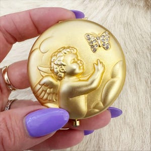 Estée Lauder August Angel gold rhinestone mirrored compact.