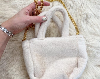 Y2K faux fur top handle bag with a gold chain.