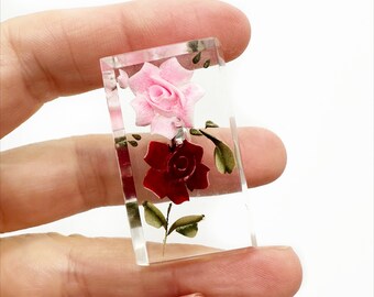 Espectacular broche de resina con intaglio invertido de rosas rojas y rosas.