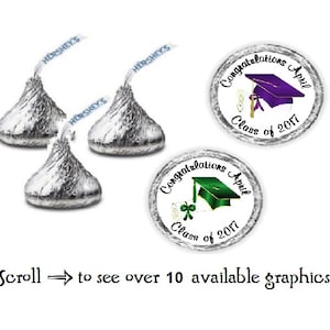 May include: Three silver Hershey's Kisses with graduation cap stickers. The stickers are white with black text that reads "Congratulations April Class of 2017". One sticker features a purple graduation cap, and the other features a green graduation cap.