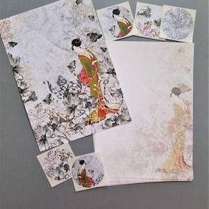 May include: A stationery set featuring a Japanese woman in a floral kimono with butterflies. The set includes a sheet of paper, an envelope, and four stickers with different designs.