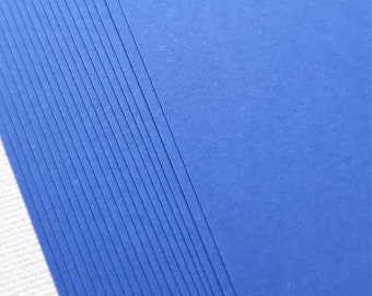 May include: A stack of blue cardstock paper with a textured surface.