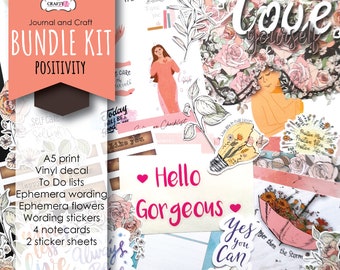 May include: A pink and white bundle kit for journaling and crafting with the words "Journal and Craft Bundle Kit Positivity" on a pink background. The kit includes A5 prints, vinyl decals, to do lists, ephemera wording, ephemera flowers, wording stickers, notecards, and sticker sheets. The kit features a variety of positive messages and images, including flowers, a lightbulb, and an umbrella.