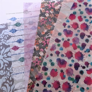May include: Five sheets of decorative transparent paper with different patterns. The patterns include a floral design, a geometric design, a watercolour splatter design, a striped design, and a damask design.