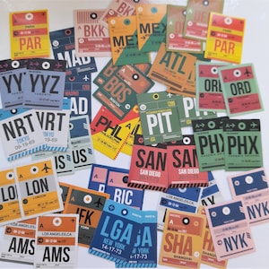 May include: A collection of colourful luggage tags featuring airport codes and city names. The tags are made of paper and have a vintage look. Some of the tags have arrows pointing to the right, while others have a circle with a line through it. The tags are arranged in a random pattern on a white background.