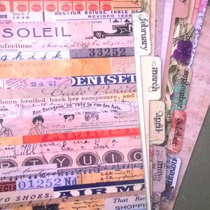 May include: A close-up of a vintage-style scrapbook with colourful paper scraps and tabs labelled with months of the year. The scrapbook is filled with handwritten notes, music sheets, and other ephemera.