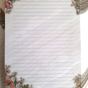 May include: A white lined paper with a floral border. The border features pink roses, green leaves, and a dotted line.