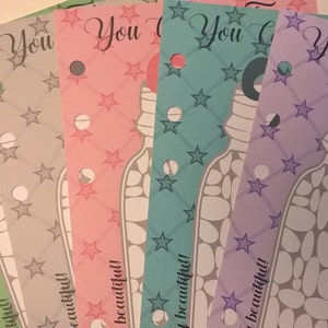 May include: Five printable cards with a jar of rocks design. The cards are in different colors: green, gray, pink, blue, and purple. Each card has the text "You" or "You Can Do" and the phrase "so beautiful!" at the bottom.