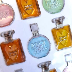 May include: Assortment of clear glass perfume bottles with heart-shaped designs and text that reads "Best Friends Forever" and "Forever Yours".
