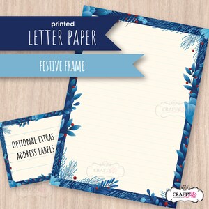 May include: Printed letter paper with a festive frame design. The paper has a cream-colored background with blue floral and berry accents. The text "Letter Paper" and "Festive Frame" are displayed on the image, along with "Optional Extras Address Labels".