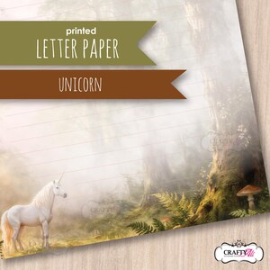 May include: A sheet of lined letter paper featuring a printed forest scene with a white unicorn standing on the left. The background shows misty trees, ferns, and a mushroom. Text overlays read printed LETTER PAPER and UNICORN in brown banners.